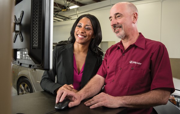 two Jiffy Lube salesperson printing coupons for synthetic oil change