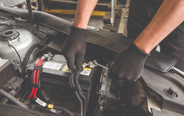 Jiffy Lube car mechanic replacing a car's battery