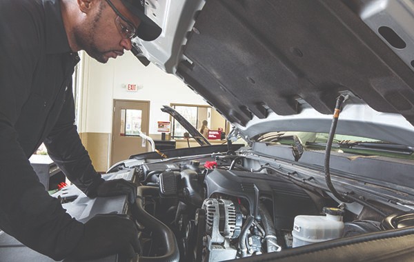 Jiffy Lube car expert replacing a car's battery