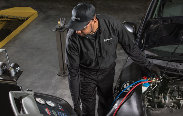 Jiffy Lube car expert checking the A/C system of a car