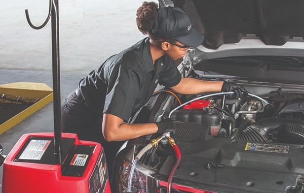 Jiffy Lube woman mechanic doing a routine transmission service