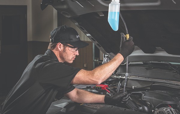 Jiffy Lube car mechanics doing a fuel system cleaning