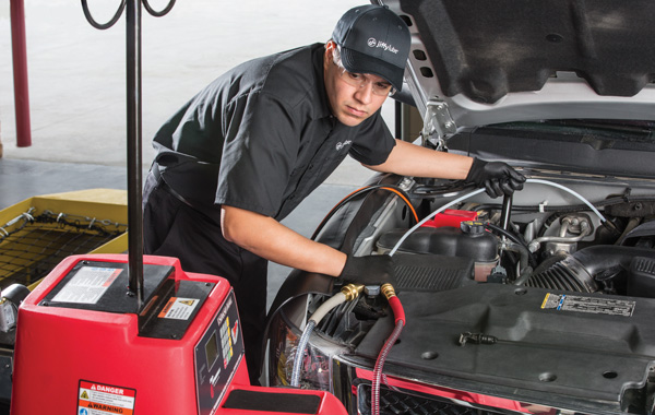 Jiffy Lube mechanics doing a fluid exchange as part of Jiffy Lube Transmission Service