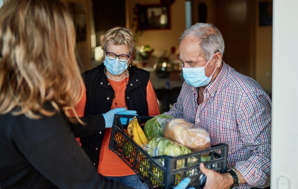 senior citizen holding a basket of goods